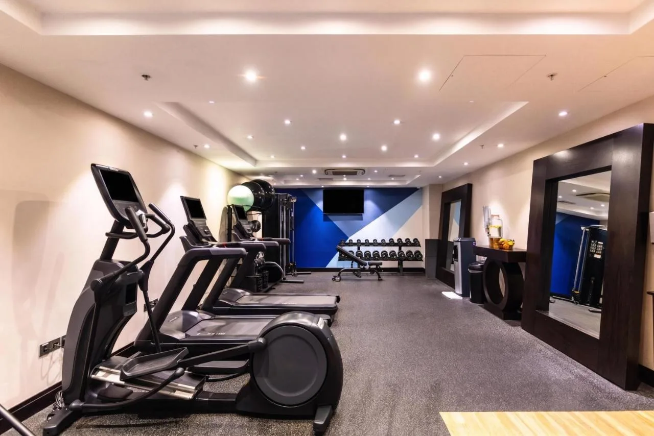 a gym with treadmills and elliptical machines at DoubleTree by Hilton London Victoria in London