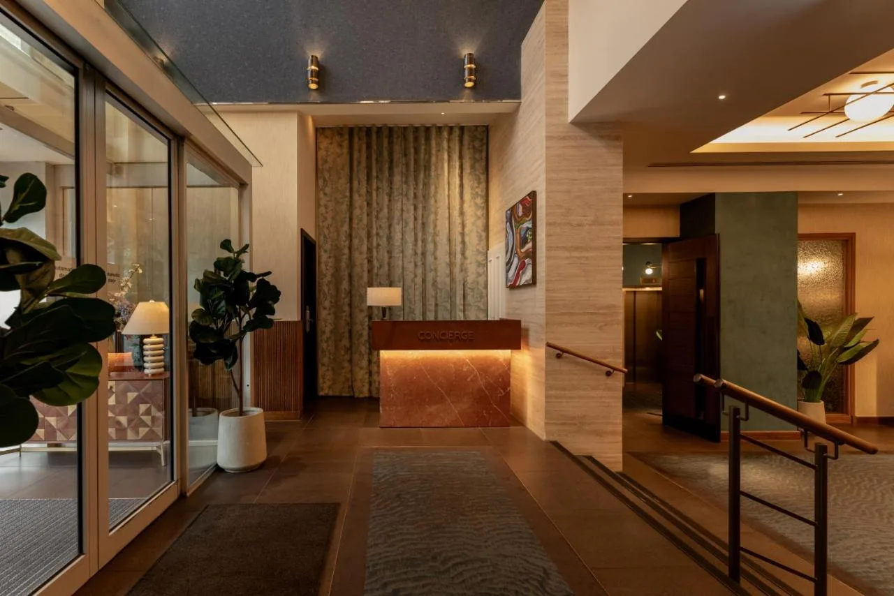 a lobby of a hotel with a hallway with plants at DoubleTree by Hilton London Victoria in London