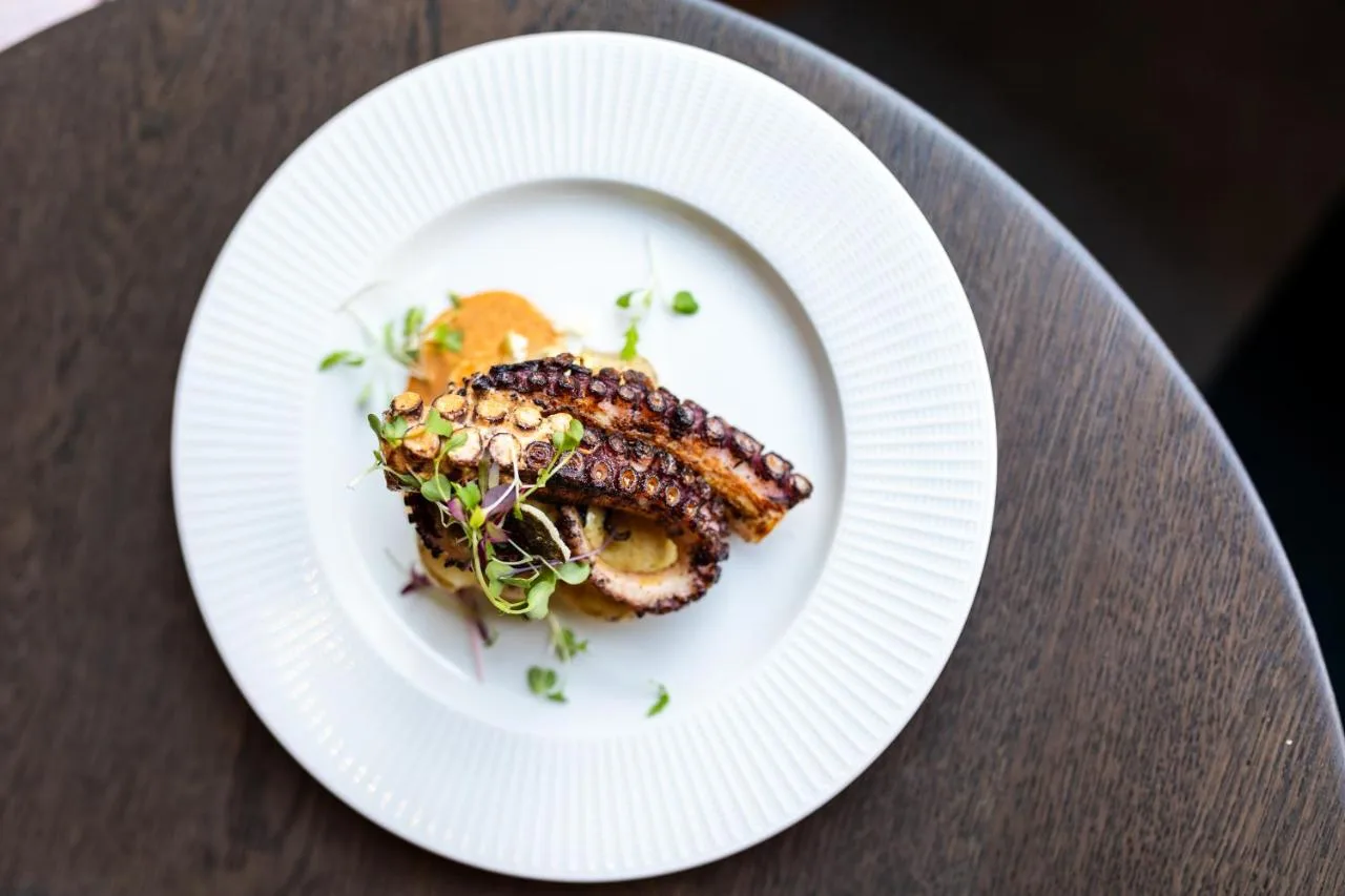 a white plate with food on a table at DoubleTree by Hilton London Victoria in London